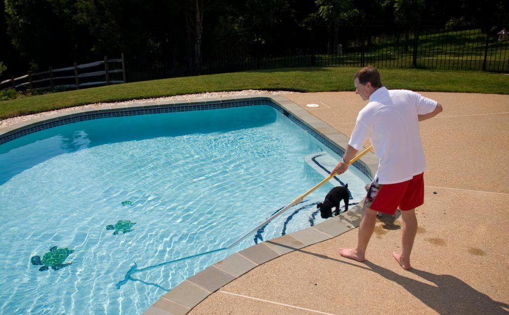 man cleaning his pool